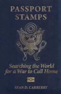 Passport Stamps: Searching the world for a war to call home, a memoir by Sean D. Carberry. Front cover is reminiscent of the front of a US Passport, but the emblem, an eagle has been altered. This eagle has a camera iris over his head, a microphone in one claw, and a bottle in the other, spilling its contents. It is outlined in gold on a dark blue background.